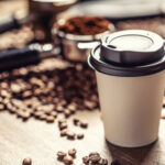163696078-taza-de-papel-para-llevar-con-tapa-de-plástico-con-café-con-granos-de-café-y-café-molido-en-el
